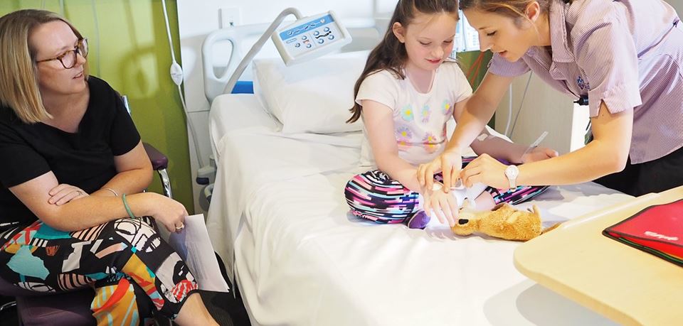 A nurse looks after a young girls in a hospital room