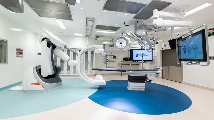 AI imaging robot stands next to an operating table.