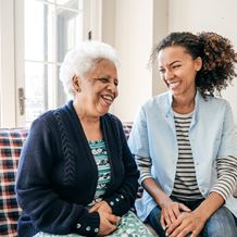 A young woman laughs with an elderly patient