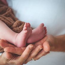 a baby's feet are in a womans hands